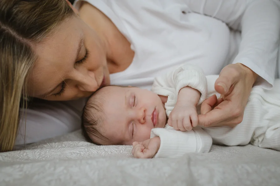 Mother kissing newborn baby